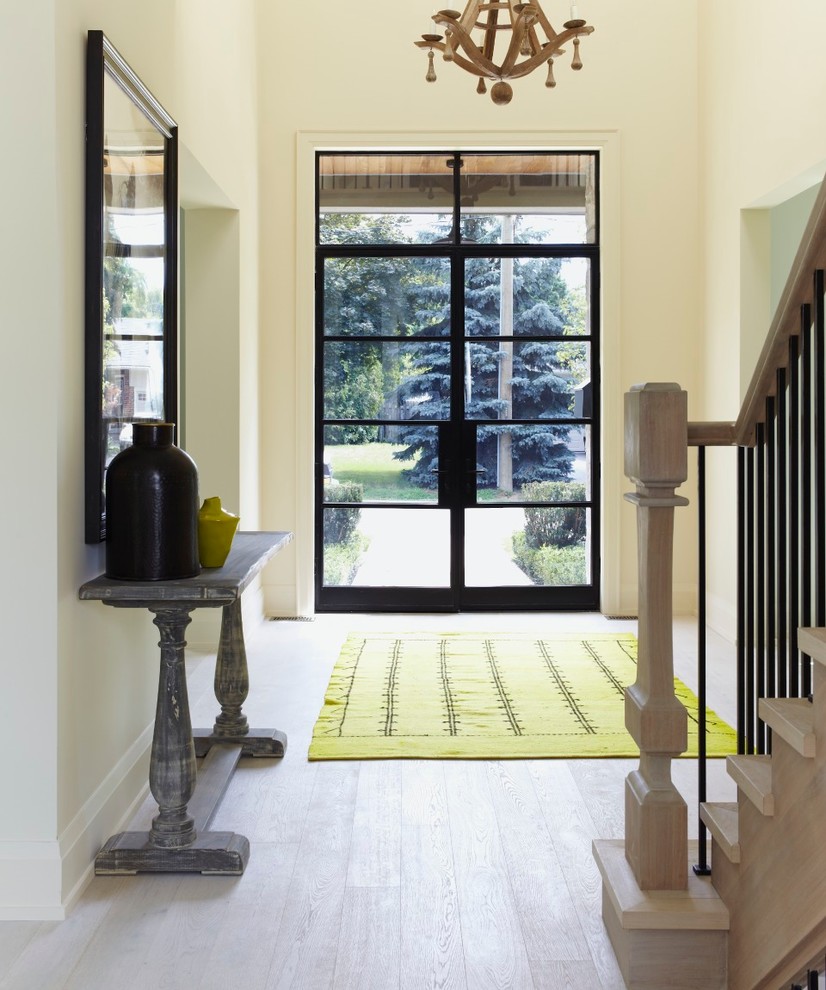 Ejemplo de puerta principal contemporánea de tamaño medio con paredes beige, puerta doble, puerta de madera clara, suelo laminado y suelo beige