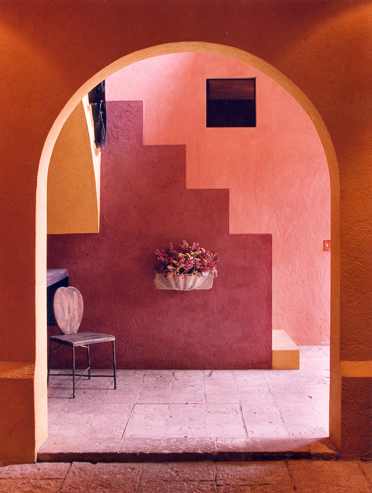 Idee per un piccolo ingresso tropicale con pareti multicolore e una porta a due ante