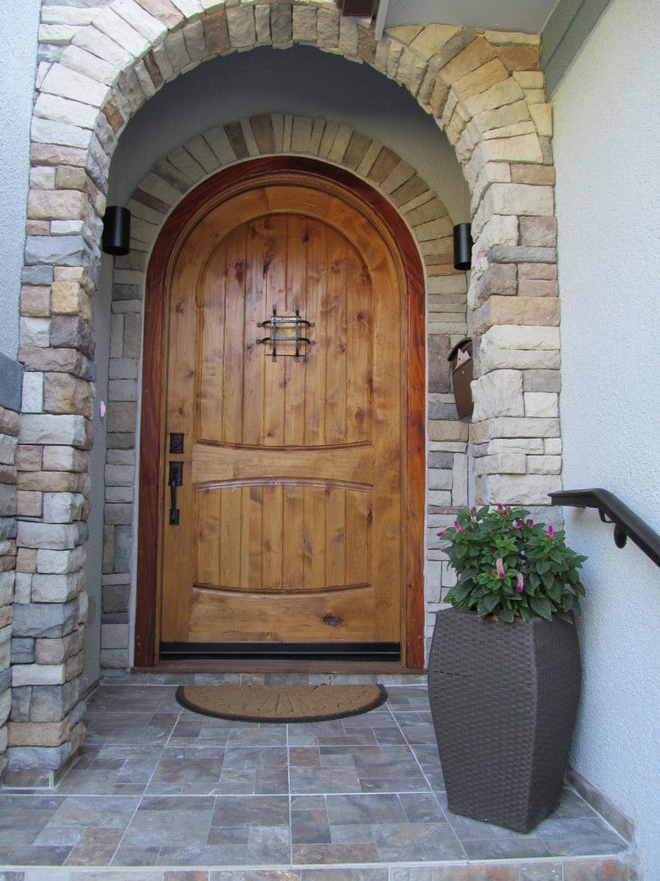 Inspiration pour une grande porte d'entrée sud-ouest américain avec une porte simple et une porte en bois brun.