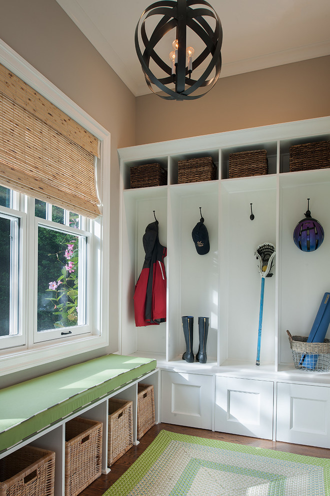 Idée de décoration pour une entrée tradition de taille moyenne avec un vestiaire, un mur beige, parquet foncé et une porte simple.