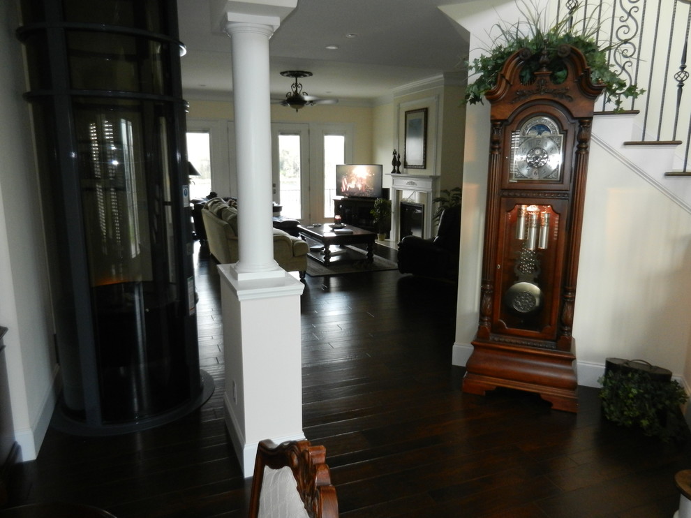Mittelgroßes Klassisches Foyer mit gelber Wandfarbe, dunklem Holzboden, Doppeltür und dunkler Holzhaustür in Charleston