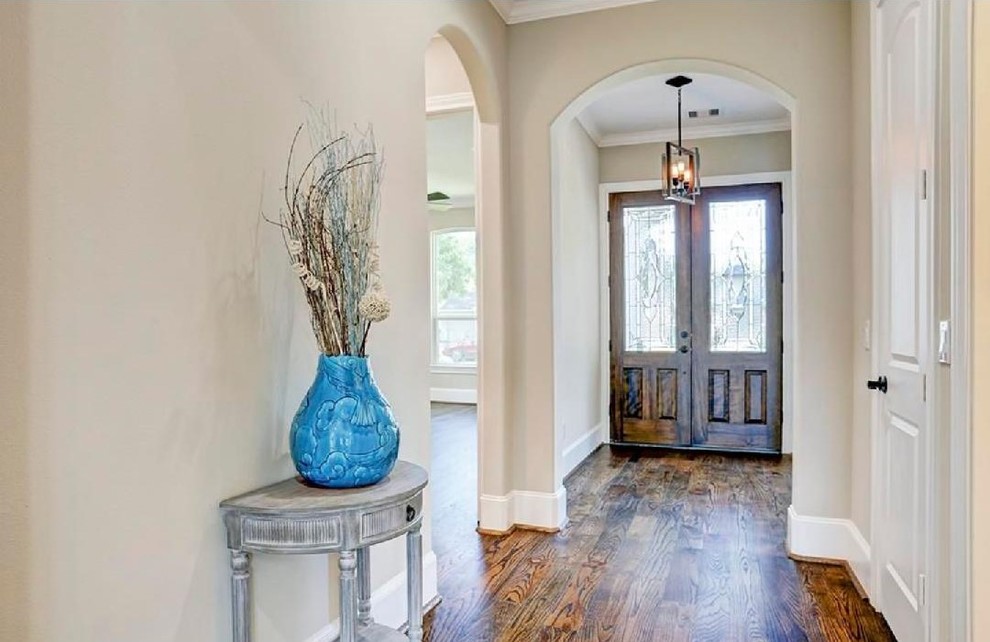 Mittelgroßes Klassisches Foyer mit beiger Wandfarbe, dunklem Holzboden, Doppeltür, brauner Haustür und braunem Boden in Houston