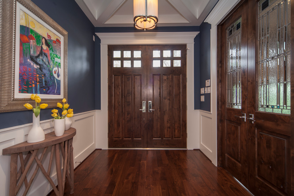 Diseño de distribuidor clásico de tamaño medio con paredes azules, suelo de madera oscura, puerta doble, puerta de madera oscura y suelo marrón