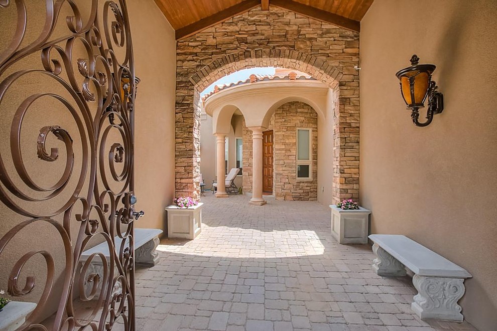 На фото: фойе среднего размера в средиземноморском стиле с бежевыми стенами, одностворчатой входной дверью и входной дверью из дерева среднего тона с