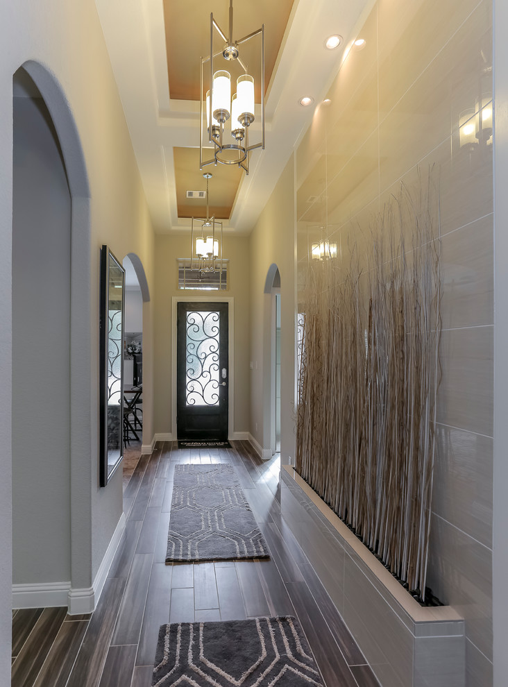 Modelo de hall de tamaño medio con paredes beige, suelo laminado, puerta simple y puerta de vidrio
