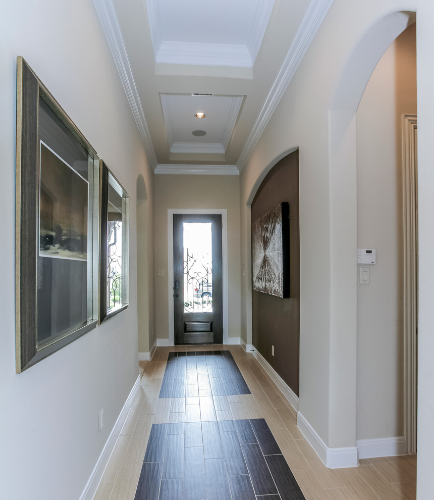 Idée de décoration pour une grande entrée tradition avec un couloir, un mur beige, sol en stratifié, une porte simple et une porte en verre.