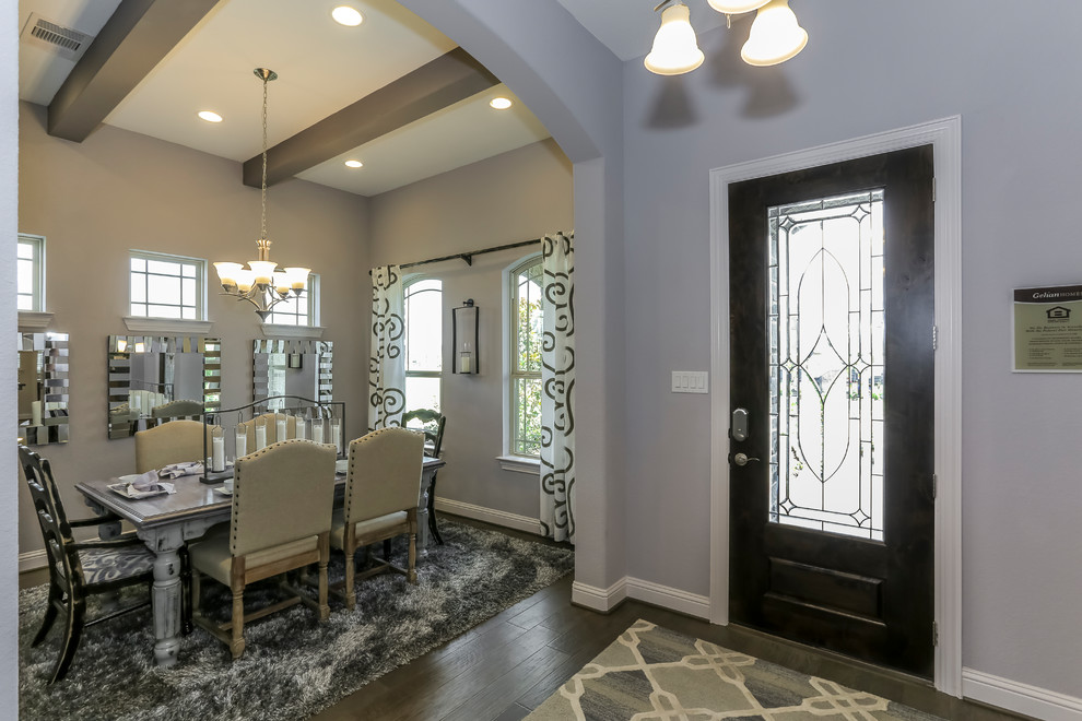 Mittelgroße Haustür mit lila Wandfarbe, dunklem Holzboden, Einzeltür, dunkler Holzhaustür und braunem Boden in Houston