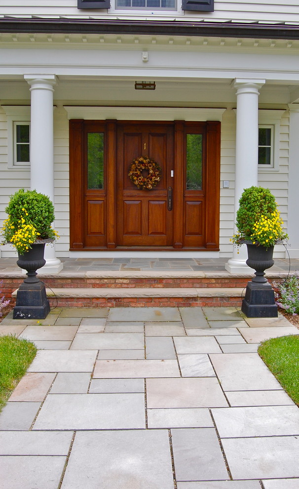 Idée de décoration pour une porte d'entrée tradition avec une porte simple et une porte en bois brun.