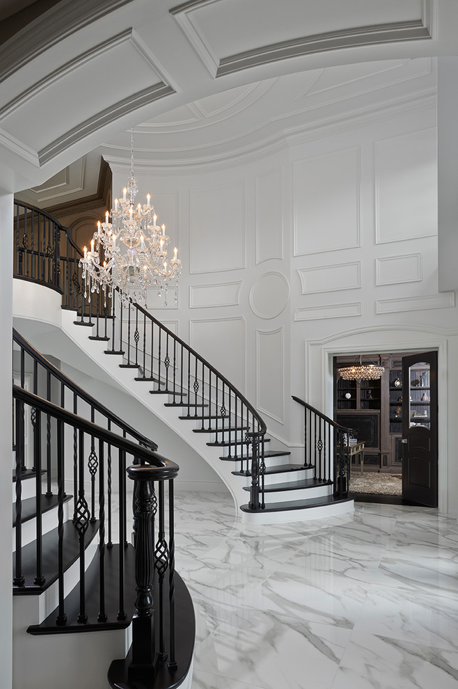Aménagement d'un très grand hall d'entrée classique avec un mur blanc, un sol en marbre, une porte double et une porte noire.
