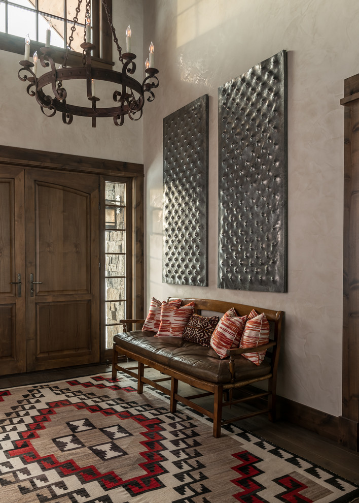 Photo of a mediterranean foyer in Other with beige walls, a double front door and a dark wood front door.