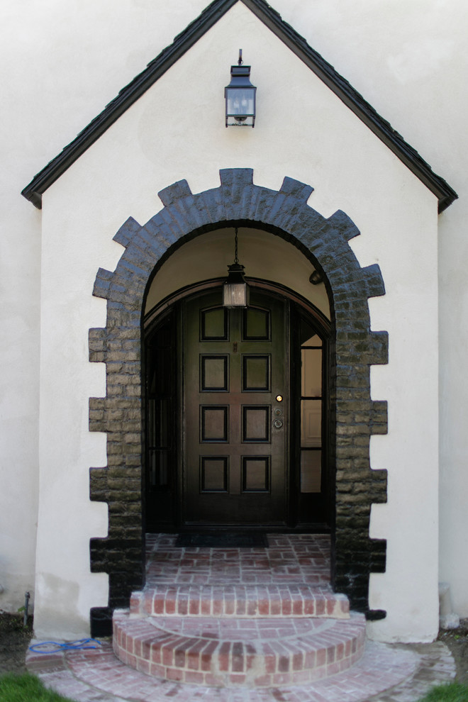 На фото: входная дверь в классическом стиле с одностворчатой входной дверью и входной дверью из темного дерева