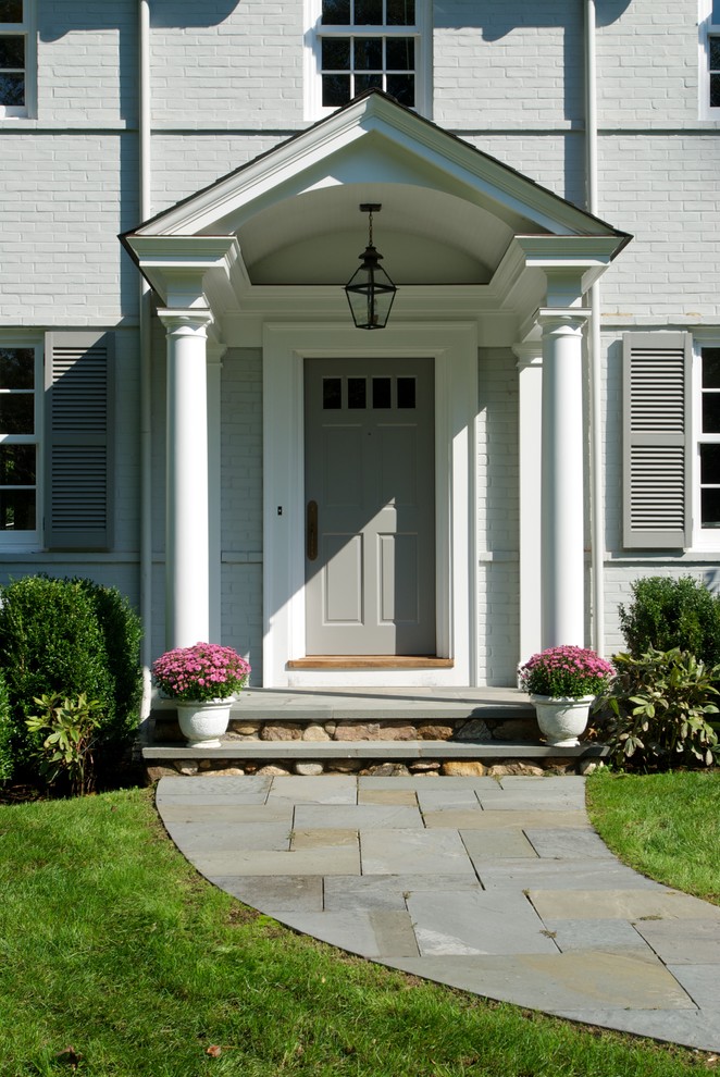 Inspiration for a traditional front door in New York with a single front door, a grey front door and feature lighting.