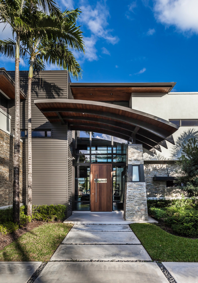 Große Moderne Haustür mit Betonboden, Drehtür, dunkler Holzhaustür und grauem Boden in Tampa