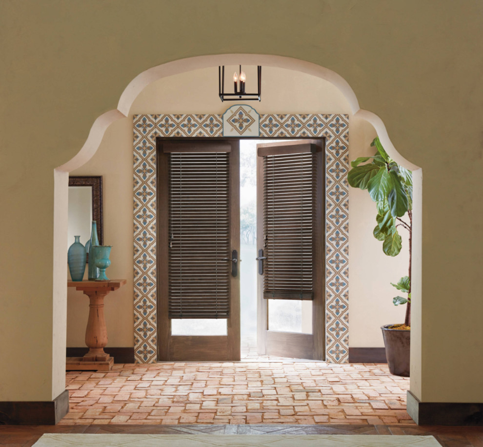 Idées déco pour une porte d'entrée sud-ouest américain de taille moyenne avec un mur beige, un sol en brique, une porte double, une porte en verre et un sol marron.