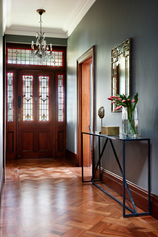 Imagen de entrada tradicional renovada con paredes azules, suelo de madera en tonos medios, puerta simple, puerta de madera en tonos medios y suelo marrón