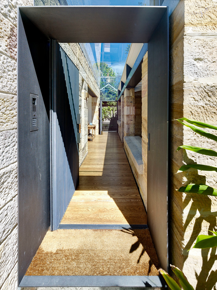 Foto på en funkis ingång och ytterdörr, med ljust trägolv, en pivotdörr, metalldörr, bruna väggar och brunt golv