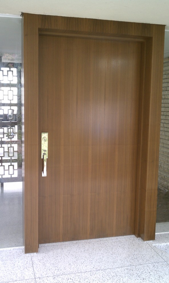 Immagine di una porta d'ingresso moderna di medie dimensioni con una porta singola e una porta in legno bruno