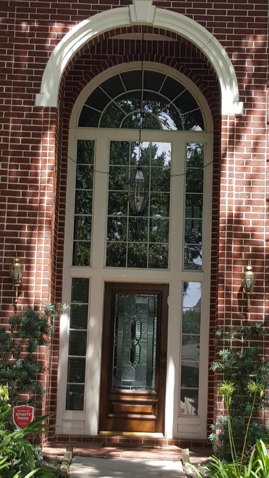На фото: большая входная дверь в классическом стиле с красными стенами, кирпичным полом, одностворчатой входной дверью и входной дверью из темного дерева с