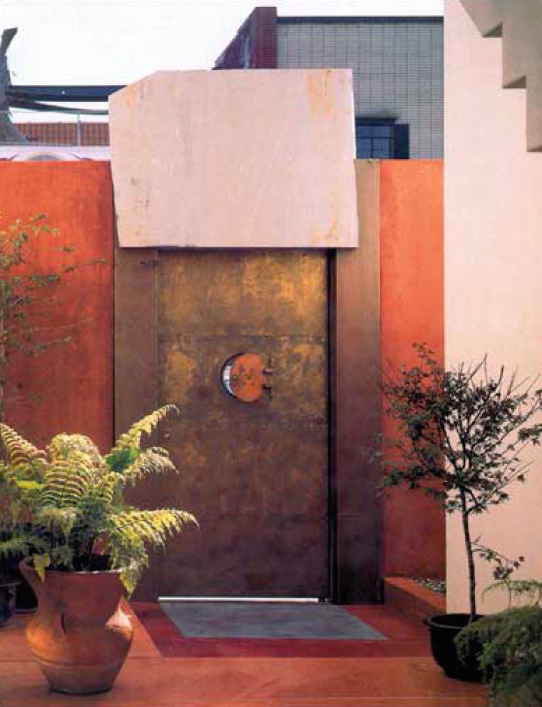 Immagine di un ingresso o corridoio contemporaneo di medie dimensioni con pareti arancioni, una porta singola e una porta marrone