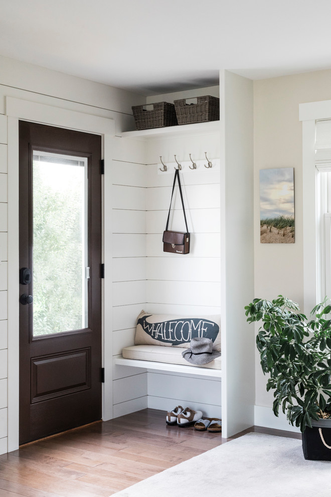 Imagen de vestíbulo posterior costero pequeño con paredes beige, suelo de madera en tonos medios, puerta simple, puerta de madera oscura y suelo gris