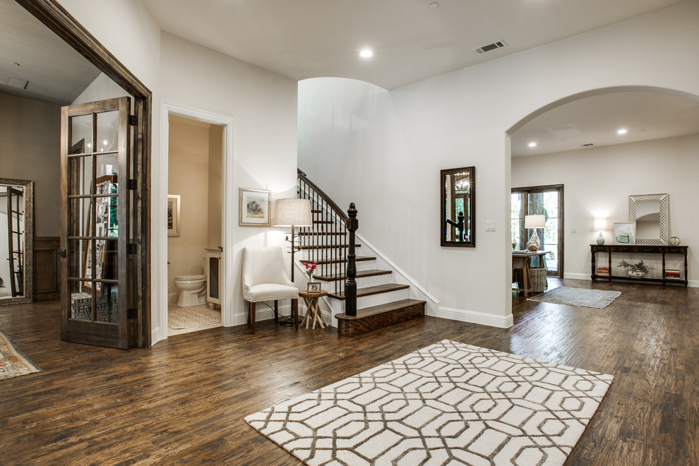 Example of a tuscan dark wood floor entryway design in Dallas with white walls and a dark wood front door
