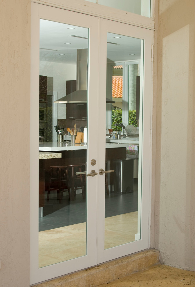 Immagine di un ingresso minimalista di medie dimensioni con pareti beige, pavimento in travertino, una porta a due ante e una porta bianca