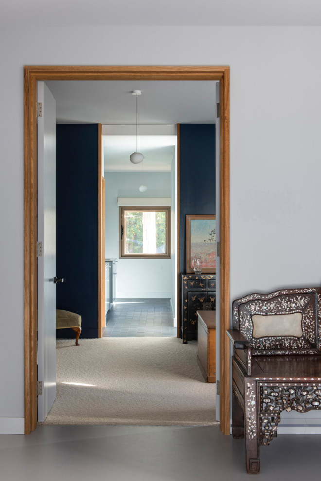 Immagine di un ingresso con vestibolo minimalista di medie dimensioni con pareti grigie, pavimento in vinile, una porta singola, una porta nera e pavimento grigio