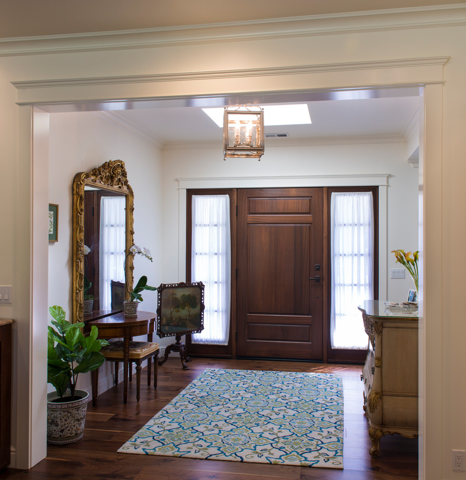 Foto di un ingresso tradizionale di medie dimensioni con pareti bianche, parquet scuro, una porta singola, una porta in legno scuro e pavimento marrone