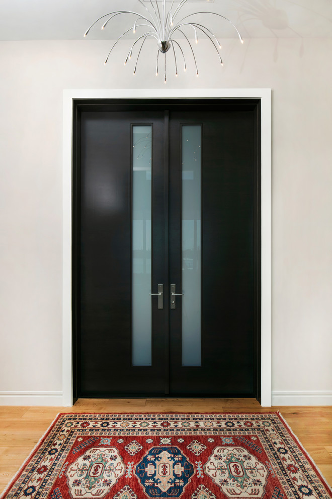 Idées déco pour une porte d'entrée contemporaine de taille moyenne avec un mur blanc, parquet clair, une porte double, une porte marron et un sol marron.