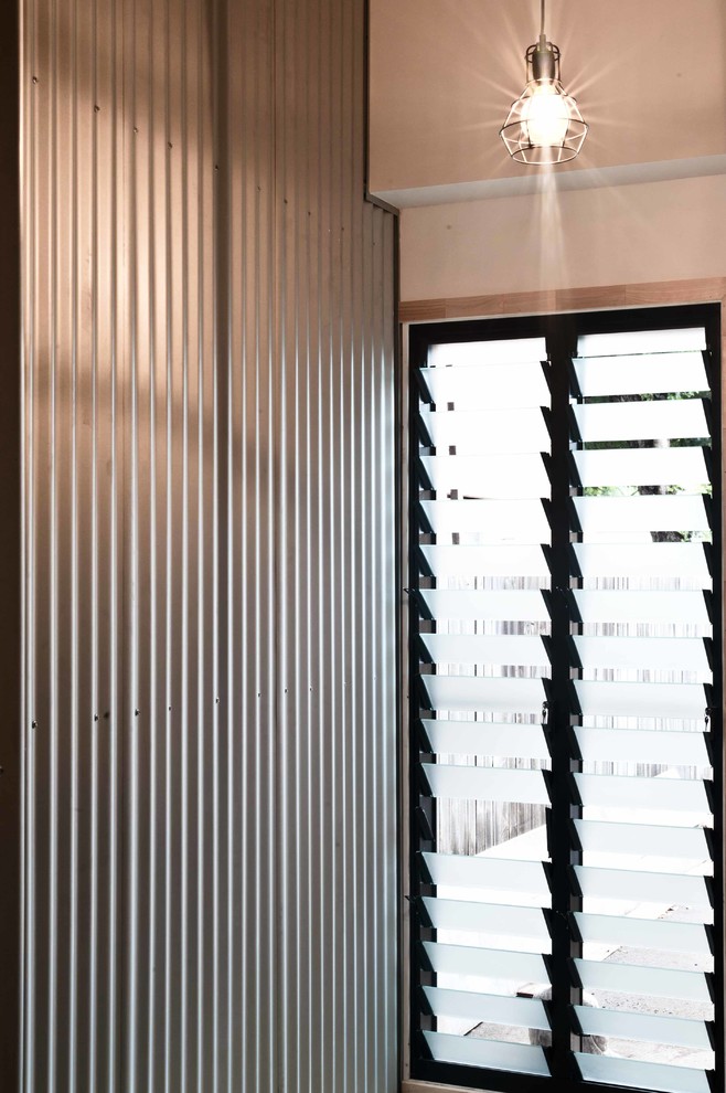 Пример оригинального дизайна: узкая прихожая среднего размера в стиле лофт с серебряными стенами и бетонным полом