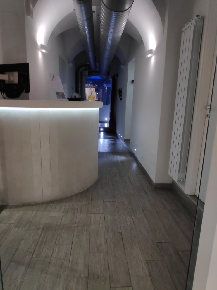 Idee per un piccolo corridoio contemporaneo con pareti bianche, pavimento in gres porcellanato, una porta scorrevole, una porta in vetro e pavimento beige