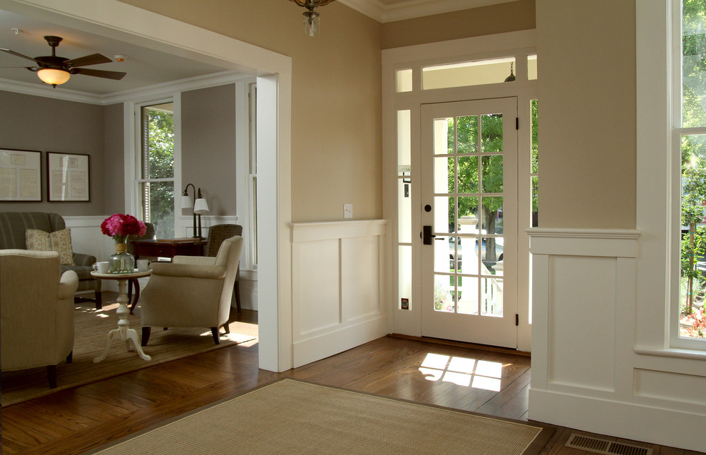 Пример оригинального дизайна: входная дверь среднего размера в классическом стиле с желтыми стенами, светлым паркетным полом, одностворчатой входной дверью и белой входной дверью