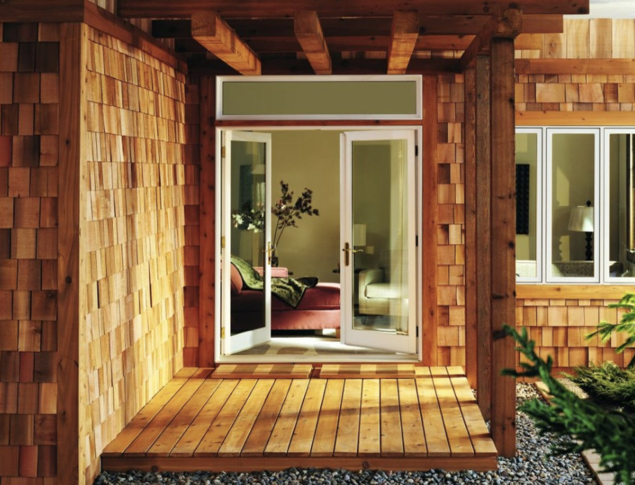 Imagen de puerta principal rural pequeña con paredes marrones, puerta doble, puerta de vidrio, suelo de madera clara y suelo marrón