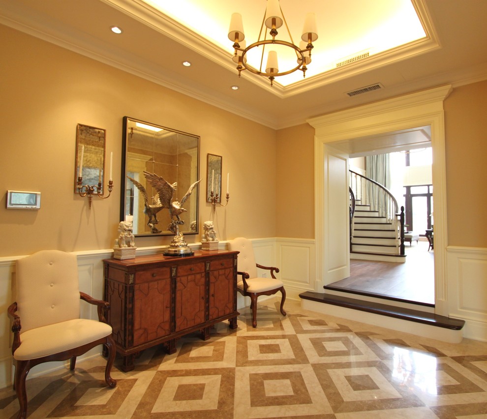Mittelgroßes Klassisches Foyer mit beiger Wandfarbe, Marmorboden und dunkler Holzhaustür in St. Louis