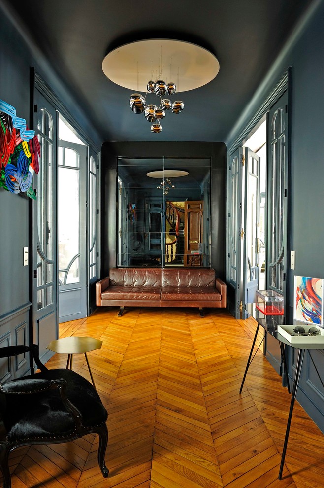 Idée de décoration pour une grande entrée bohème avec un mur gris, parquet clair, un couloir, une porte double, une porte bleue et un sol beige.