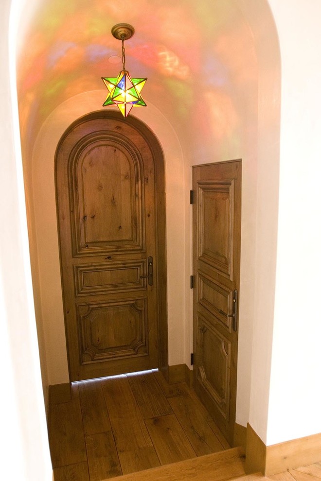 Ejemplo de puerta principal mediterránea grande con paredes beige, suelo de madera en tonos medios, puerta doble y puerta de madera en tonos medios