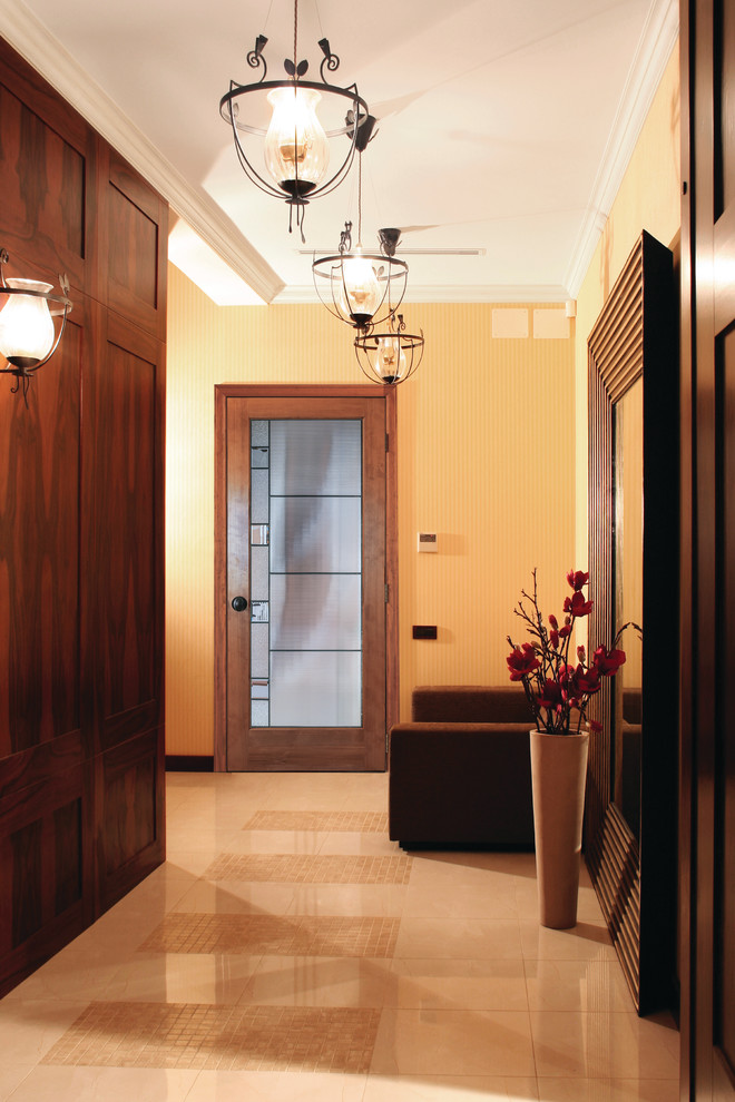 Foto di un ingresso chic di medie dimensioni con pareti arancioni, pavimento in gres porcellanato, una porta singola, pavimento marrone e una porta in vetro