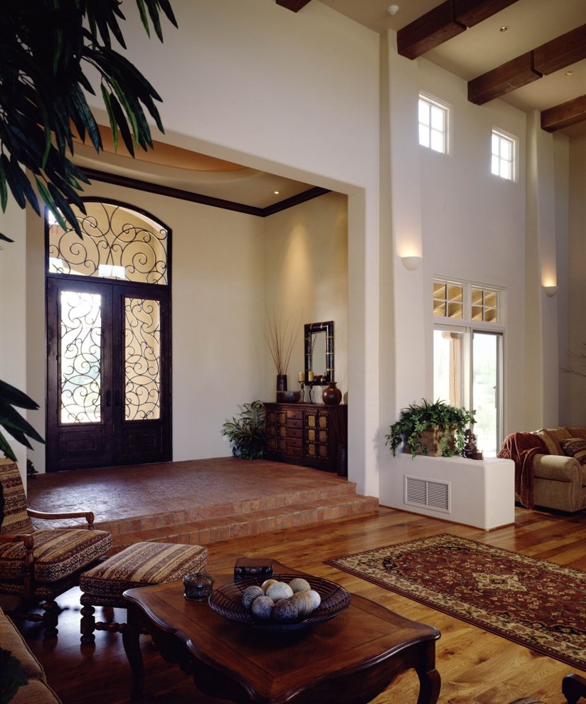 Inspiration for a huge mediterranean medium tone wood floor entryway remodel in Phoenix with white walls and a black front door