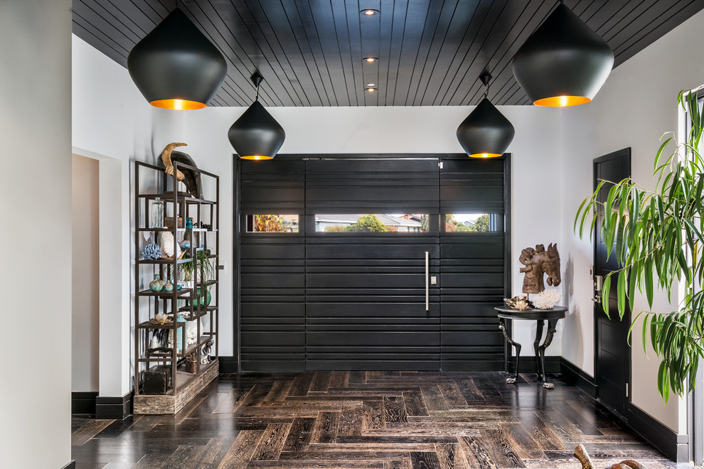 Example of a mid-sized trendy dark wood floor entryway design in San Francisco with white walls and a black front door