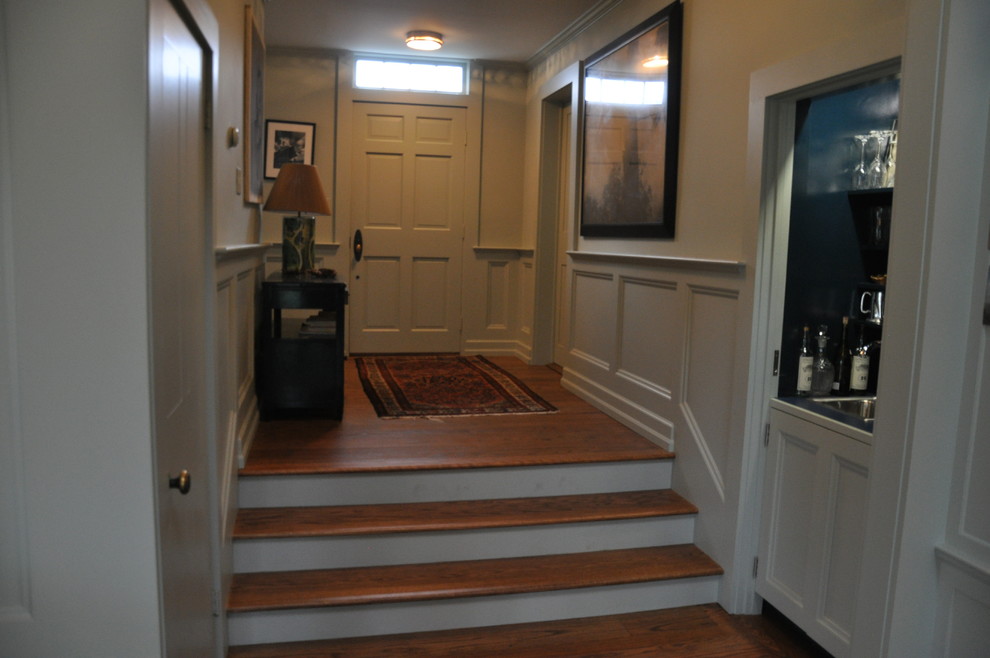 Example of a large classic medium tone wood floor entryway design in New York with green walls and a green front door