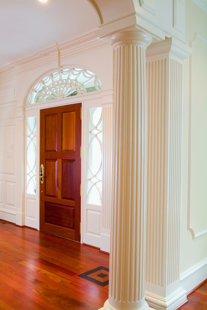 На фото: огромное фойе в классическом стиле с белыми стенами, паркетным полом среднего тона, одностворчатой входной дверью и входной дверью из дерева среднего тона с