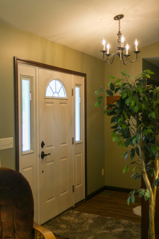 Источник вдохновения для домашнего уюта: входная дверь среднего размера в классическом стиле с одностворчатой входной дверью, белой входной дверью, зелеными стенами, полом из ламината и коричневым полом