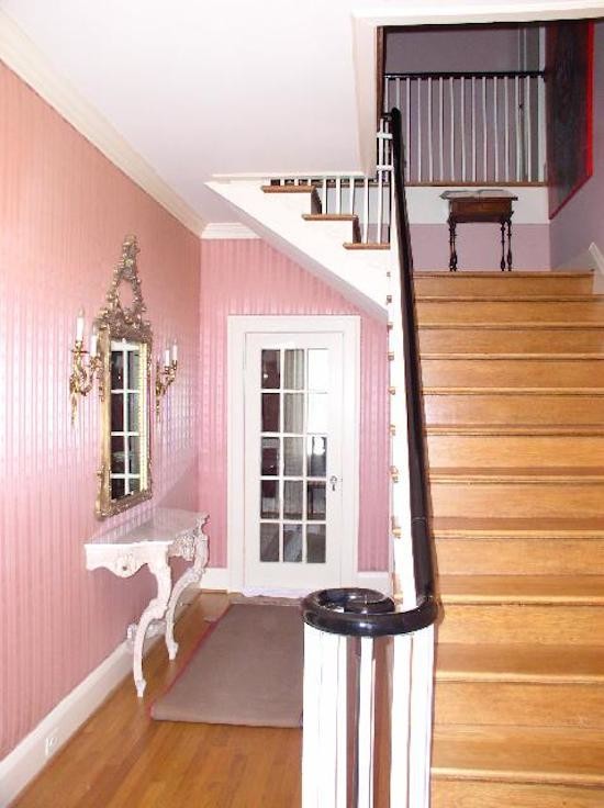 Aménagement d'une entrée avec un mur rose et parquet clair.