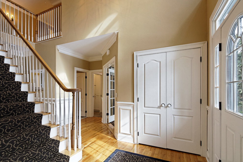 Idées déco pour un hall d'entrée classique de taille moyenne avec parquet clair, une porte simple, une porte blanche, un mur beige et un sol beige.