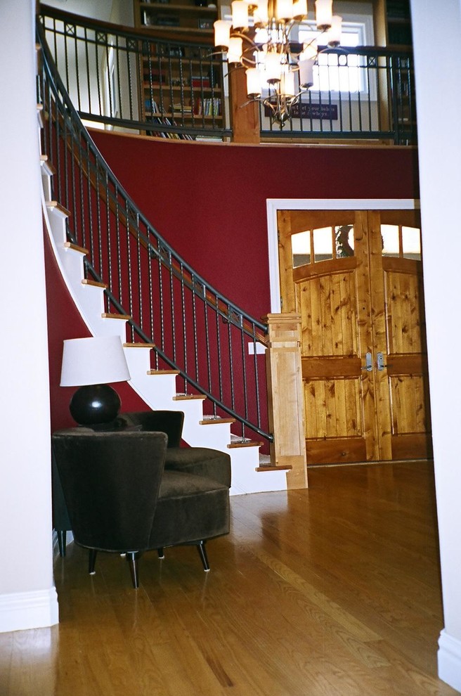 Idée de décoration pour un hall d'entrée avec un mur rouge, parquet clair, une porte double et une porte en bois brun.