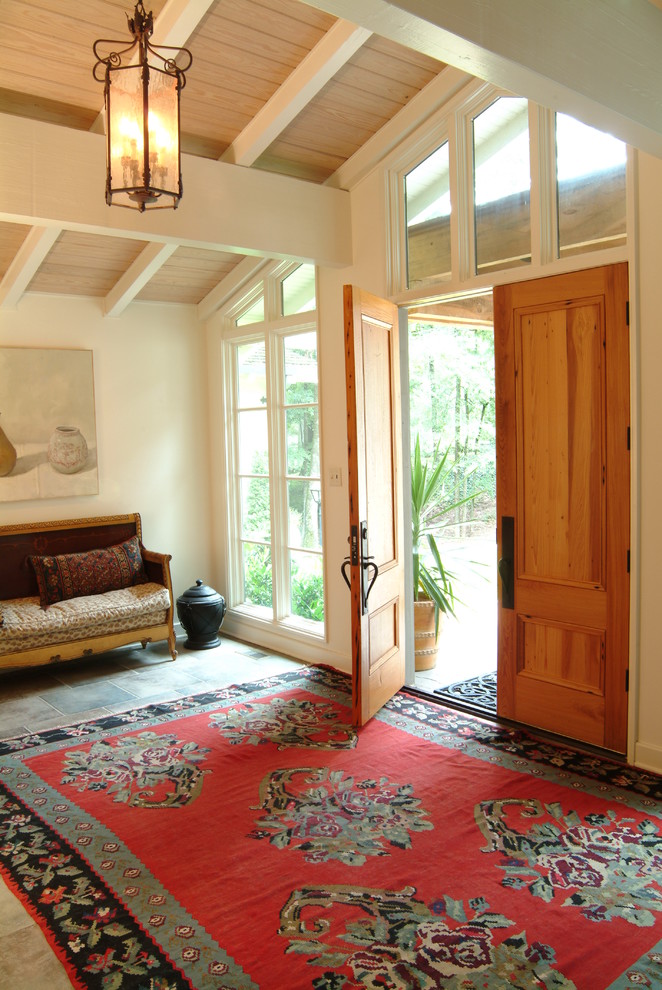 Immagine di un ingresso tradizionale con pareti bianche, una porta a due ante e una porta in legno bruno