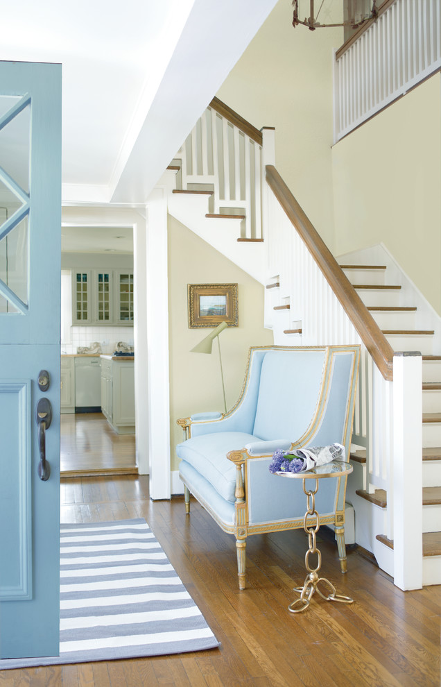 Mittelgroßes Landhaus Foyer mit gelber Wandfarbe, braunem Holzboden, Klöntür, blauer Haustür und braunem Boden in Sonstige