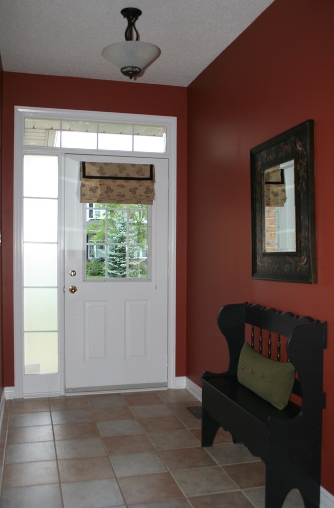 На фото: маленькое фойе в классическом стиле с полом из керамической плитки, одностворчатой входной дверью, красными стенами и бежевым полом для на участке и в саду с