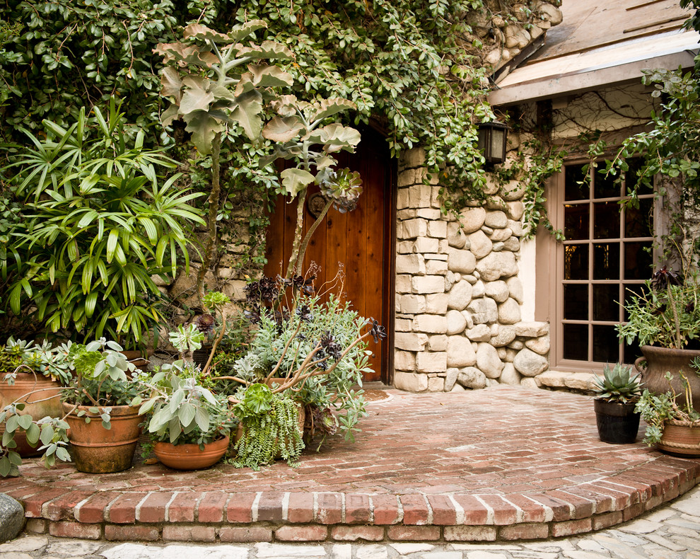 Example of a tuscan entryway design in Los Angeles with a dark wood front door