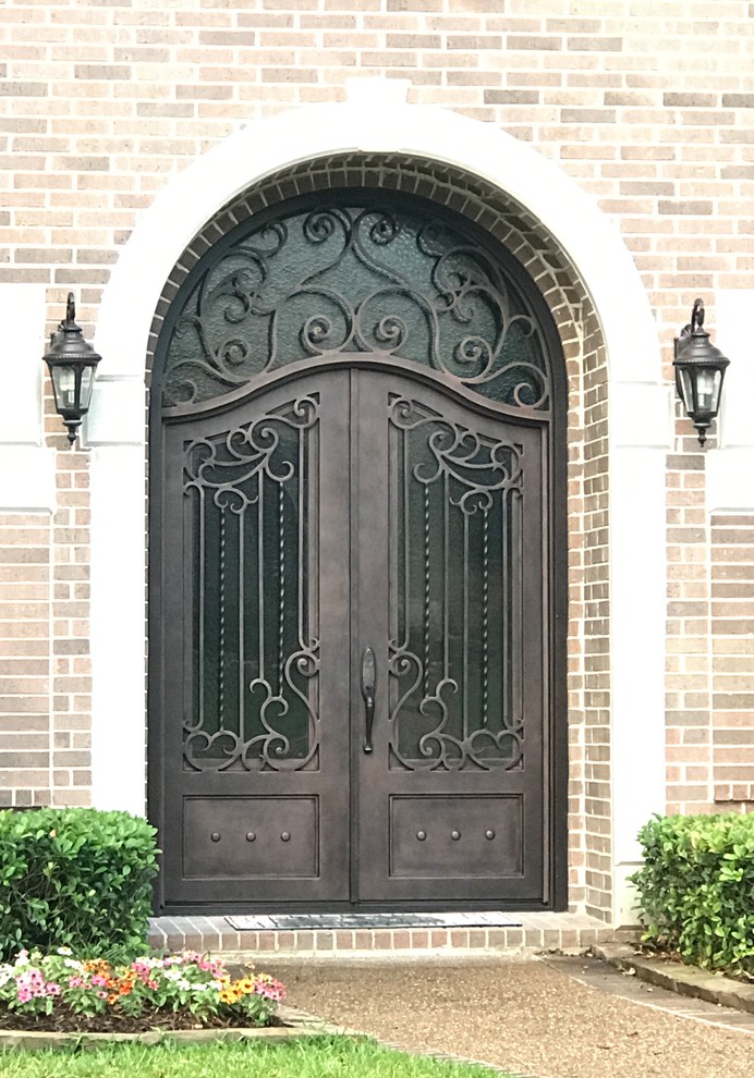 Ejemplo de puerta principal de tamaño medio con paredes rojas, suelo de ladrillo, puerta doble y puerta metalizada